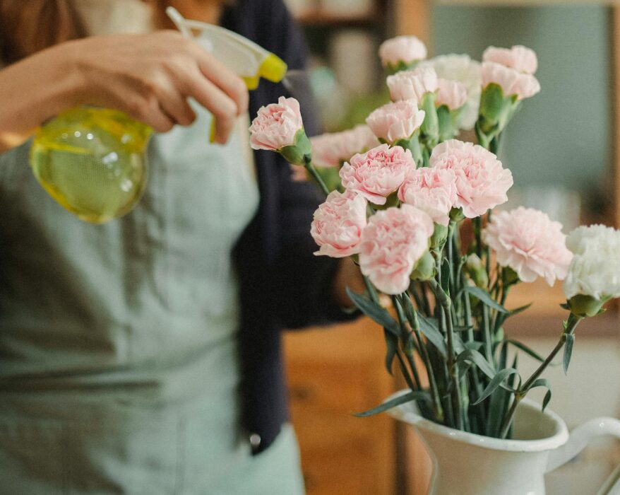 Fresh flowers in a vase on a windowsill, bathed in soft sunlight.