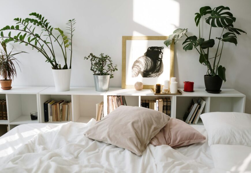 Bedroom interior with a variety of potted plants on shelves above a bed and bookshelves on either side of the bed