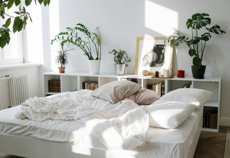 Bedroom interior with a woman arranging potted plants on shelves above a bed