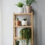 A wooden shelf filled with various potted houseplants in colorful containers.